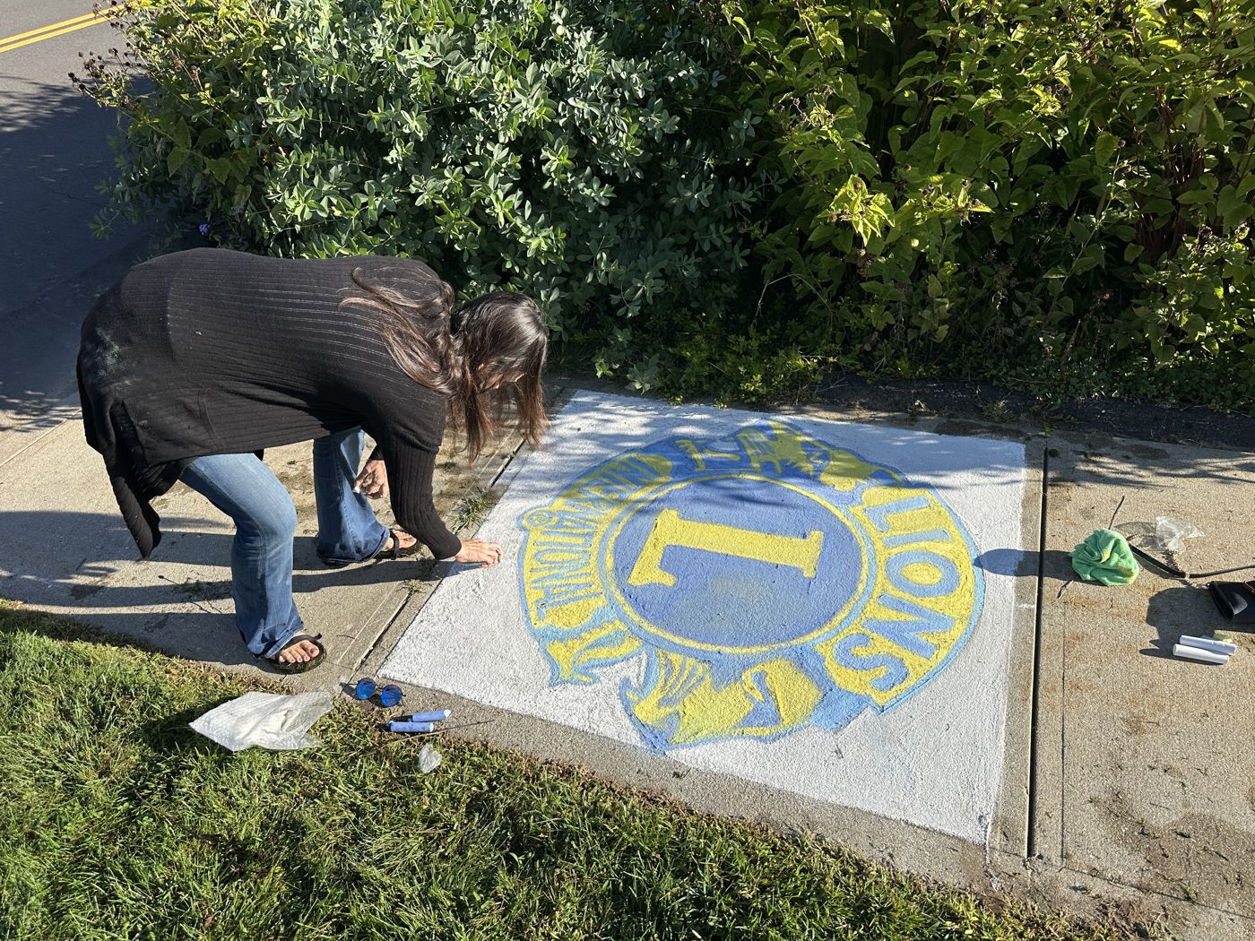 An artist finishing the chalk Lions International logo square
