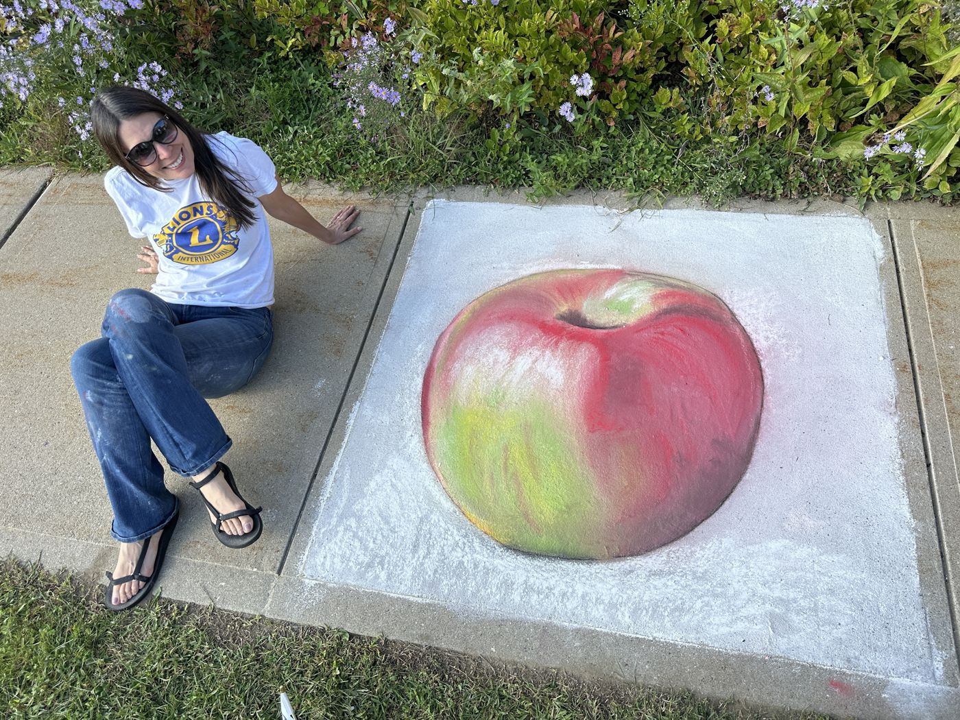 An artist posing beside her finished apple square
